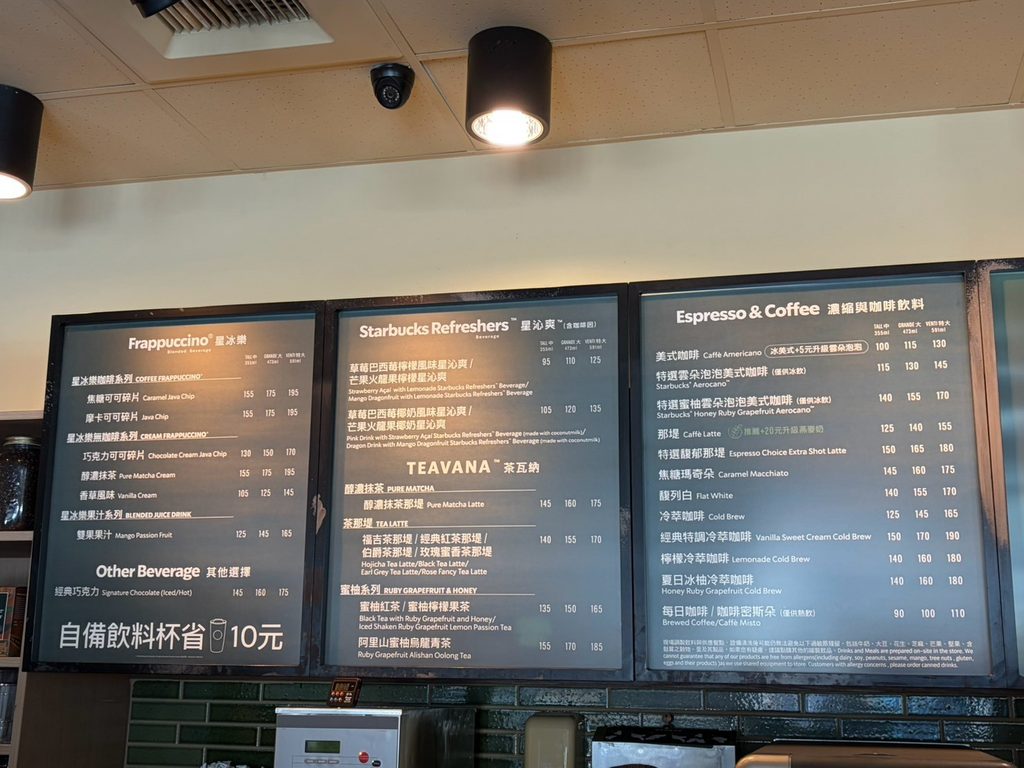 フラペチーノやティー、エスプレッソなどのドリンクメニューが英語と中国語で記載された屏東海生館門市のメニューボード。
