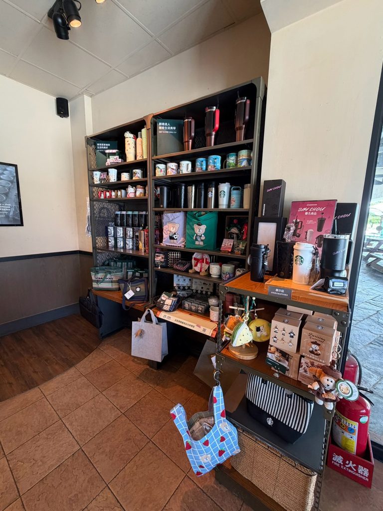 屏東海生館門市の店内で、タンブラーや漁師網バッグなどの多様なオリジナルグッズが並ぶディスプレイ棚。