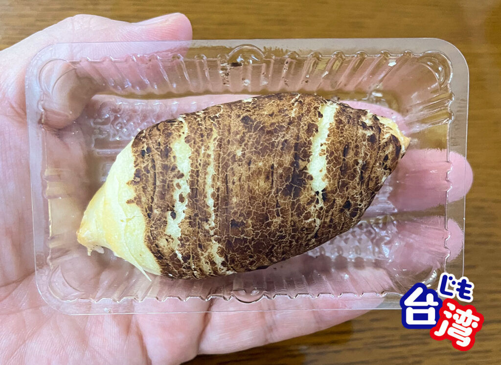 手のひらに乗せた阿聰師のタロイモケーキ「小芋仔」。表面の焼き色や質感がリアルに再現されており、本物のタロイモのような見た目をしている